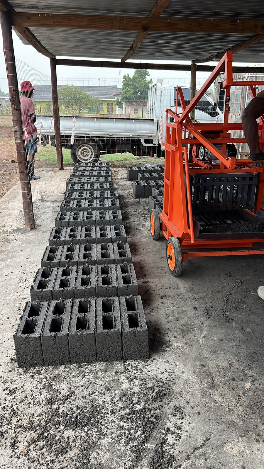 Fresh concrete building blocks coming off the Masinga block machine